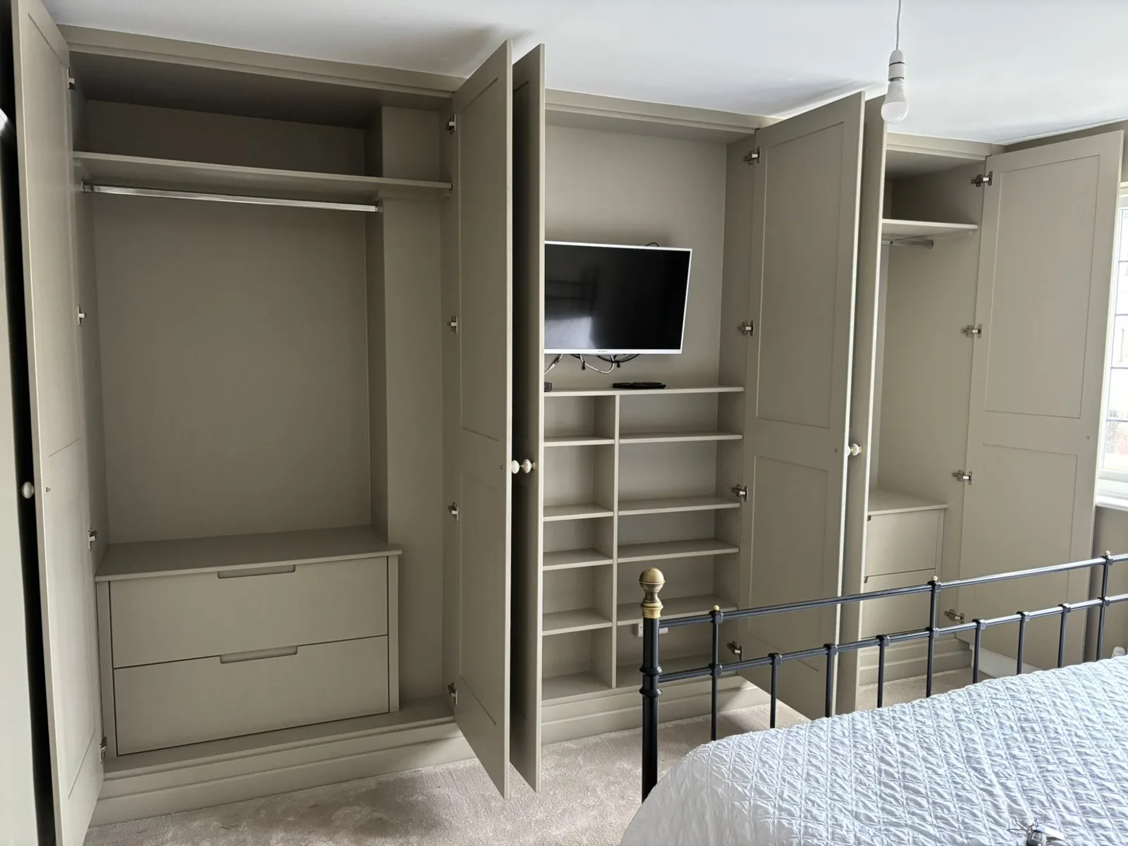 Full wall fitted wardrobe with TV alcove and shoe storage in a Bristol home