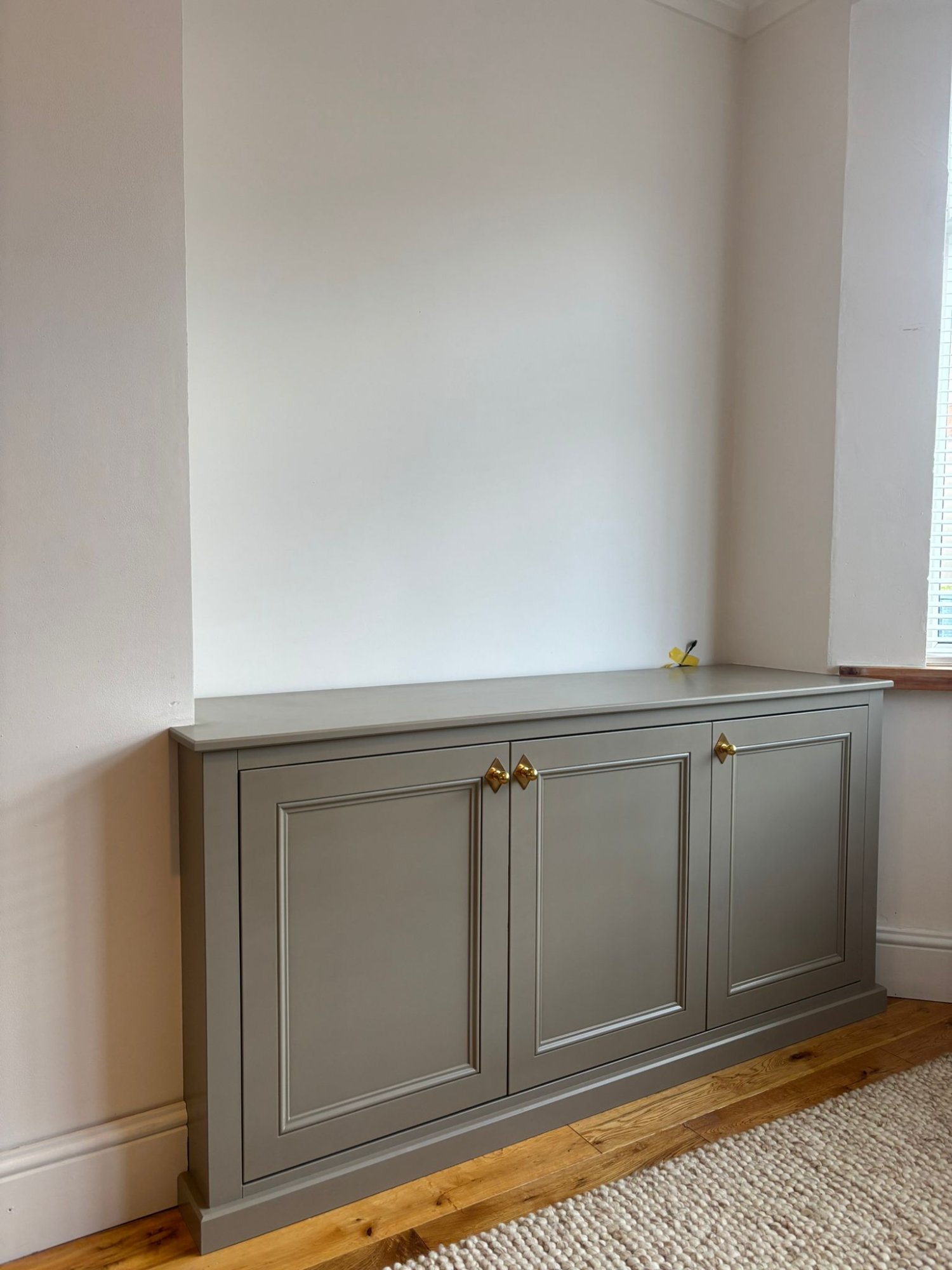 Bespoke alcove storage unit with brass hardware
