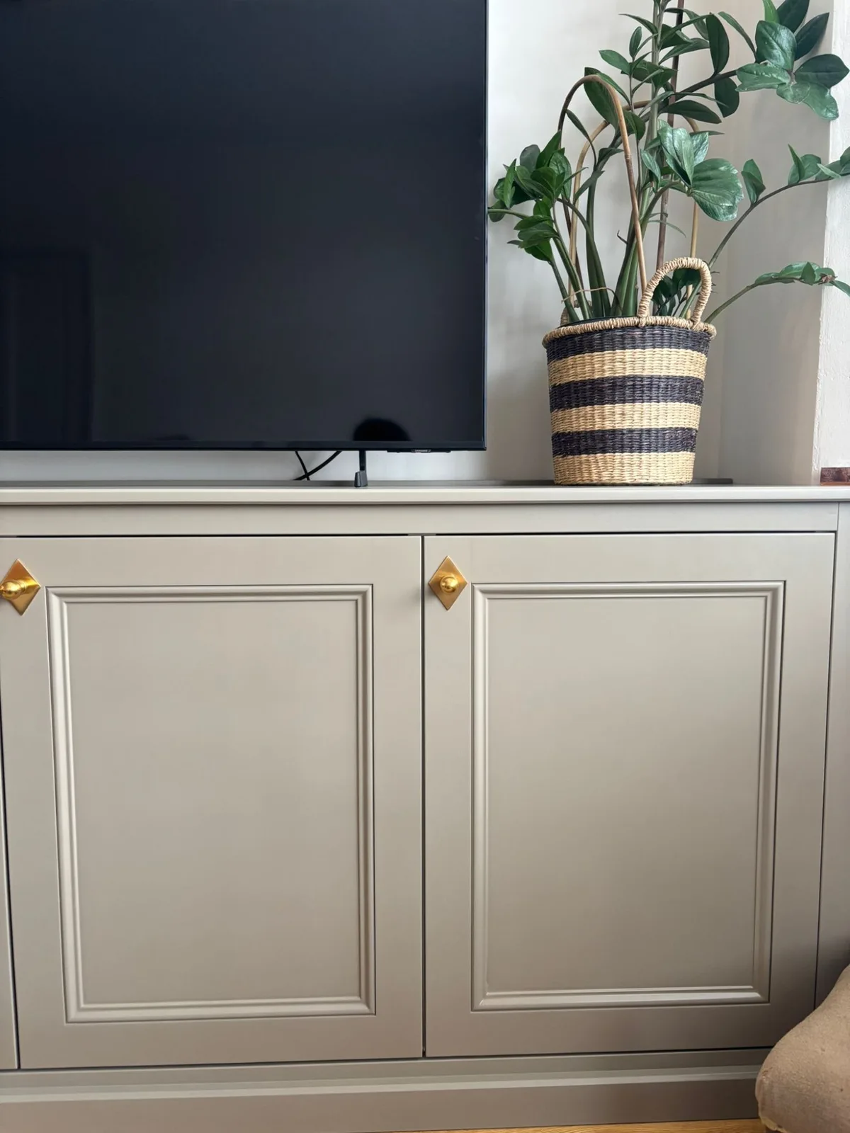 Custom TV unit with panelled doors and brass handles