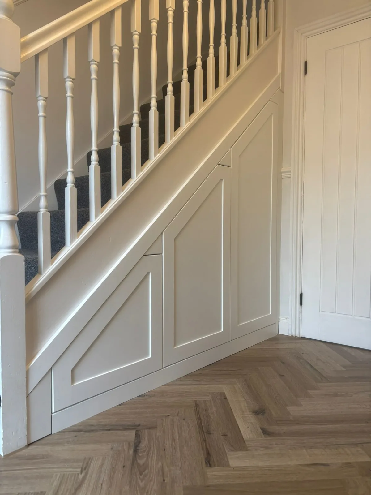 Bespoke under-stair cupboards with panelled doors in a Bristol hallway